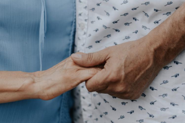 patient and relative holding hands
